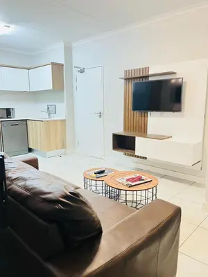 a living room with a couch and a table at The blyde apartment in Pretoria