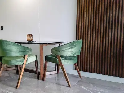 two green chairs sitting next to a wooden table at Ellipse Waterfall Executive Two Bedroom in Midrand