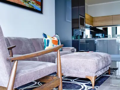 a living room with a couch and a chair at Ellipse Waterfall Executive Two Bedroom in Midrand