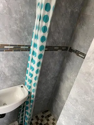 a bathroom with a shower curtain next to a sink at Maoba GuestHouse in Soshanguve