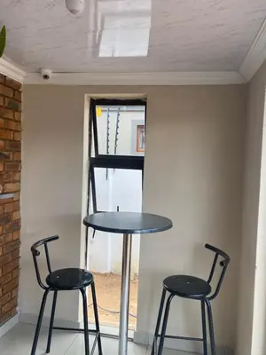 two chairs and a table in front of a window at Maoba GuestHouse in Soshanguve