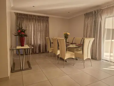 a dining room with a table and chairs at Calm house by the river in Brits