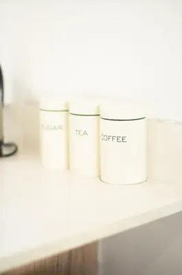 a row of white containers sitting on a shelf at The Blyde- Feel At Home in Pretoria
