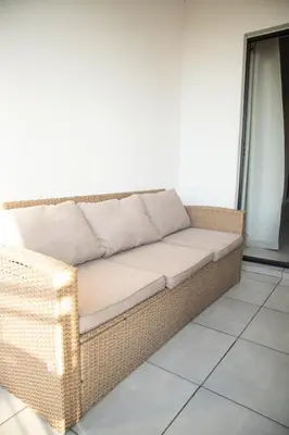 a wicker couch sitting in a room at The Blyde- Feel At Home in Pretoria