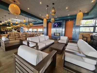 a bar with white couches and a restaurant at The Blyde- Feel At Home in Pretoria