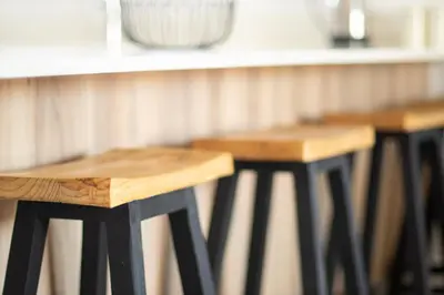 a row of wooden stools sitting next to a counter at The Blyde- Feel At Home in Pretoria