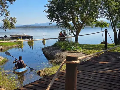 a man in a boat on a lake with a paddle at Muca House in Thohoyandou