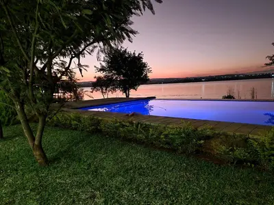 a swimming pool next to a body of water at Muca House in Thohoyandou