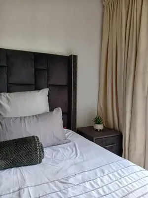 a bedroom with a large bed with a wooden headboard at The Serenity in Polokwane
