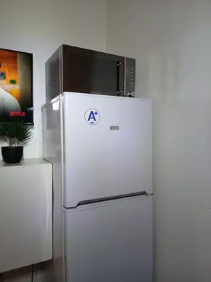 a refrigerator with a microwave on top of it at The Serenity in Polokwane