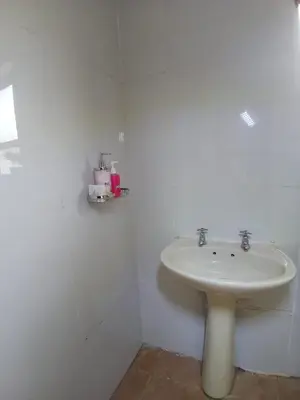 a white bathroom with a sink in a room at The Serenity in Polokwane
