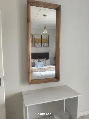 a mirror on a wall with a bed in a room at Blyde Cozy-TEE'S Apartment in Pretoria