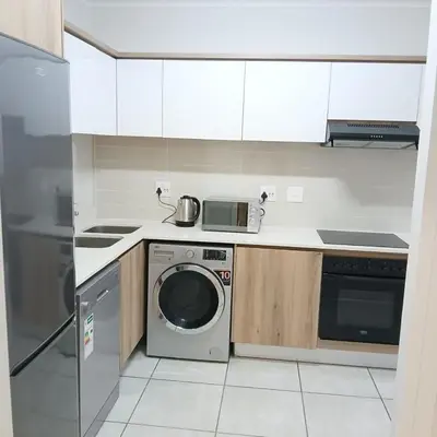a kitchen with a washing machine and a stove at Blyde Cozy-TEE'S Apartment in Pretoria