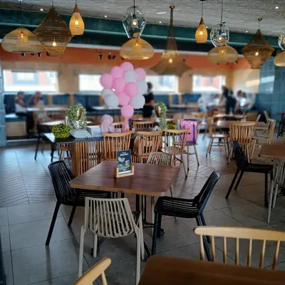 a restaurant with tables and chairs and pink balloons at Blyde Cozy-TEE'S Apartment in Pretoria