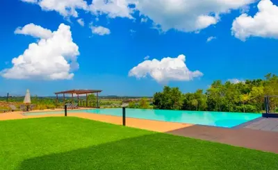 a swimming pool with a green lawn and a blue sky at Luxury palace of Life in Midrand