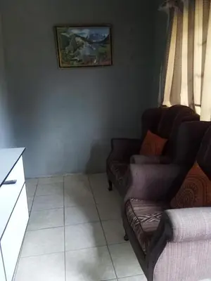 a living room with two chairs and a couch at Day & Night Guestrooms in White River