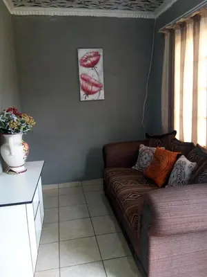 a living room with a couch and a picture of lips at Day & Night Guestrooms in White River