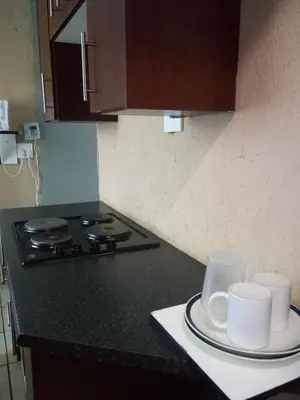 a kitchen counter with two cups and a stove at Day & Night Guestrooms in White River