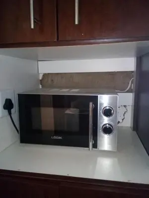 a microwave on top of a kitchen counter at Day & Night Guestrooms in White River