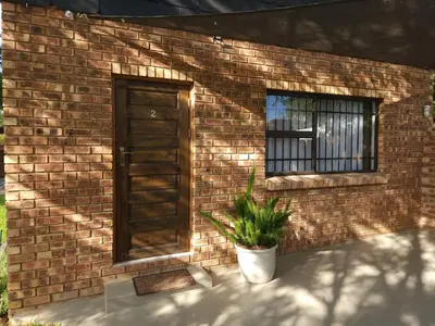 a brick building with a door and a potted plant at Bohemian Escape Midrand in Midrand