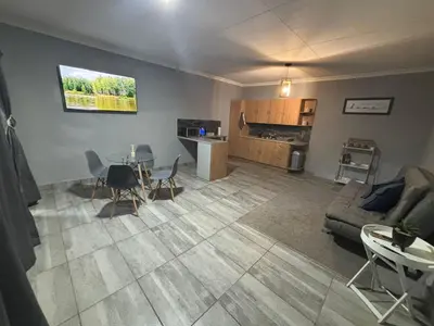 a living room with a couch and a table at Nettle Nest Accommodation in Polokwane