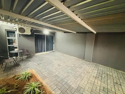 an empty room with a table and chairs in it at Nettle Nest Accommodation in Polokwane