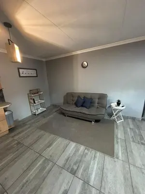 a living room with a couch and a table at Nettle Nest Accommodation in Polokwane