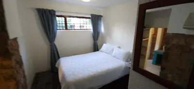a small bedroom with a bed and a mirror at Katima Mountain View Lodge in Hartbeespoort