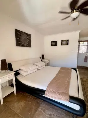 a bedroom with a bed and a ceiling fan at Katima Mountain View Lodge in Hartbeespoort