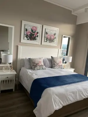a bedroom with a large bed with two pillows at Menlyn Maine Trilogy Apartment in Pretoria