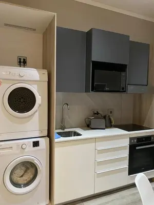 a kitchen with a washing machine and a washer at Menlyn Maine Trilogy Apartment in Pretoria