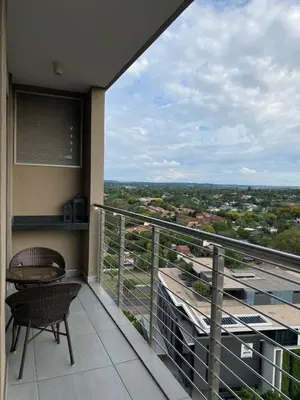 a balcony with a table and a chair on a building at Menlyn Maine Trilogy Apartment in Pretoria