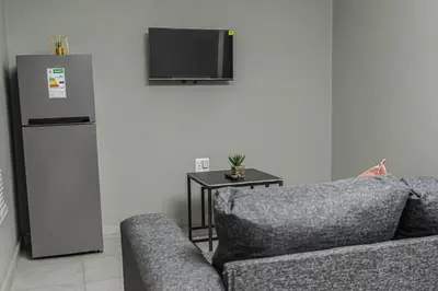 a living room with a couch and a refrigerator at Mahlakwena Crown Crest in Steelpoort
