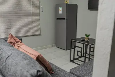 a living room with a refrigerator and a table at Mahlakwena Crown Crest in Steelpoort