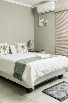 a bedroom with a large bed with white sheets and pillows at Mahlakwena Crown Crest in Steelpoort