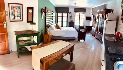a bedroom with a bed and a table in a room at Piano Inn in Centurion