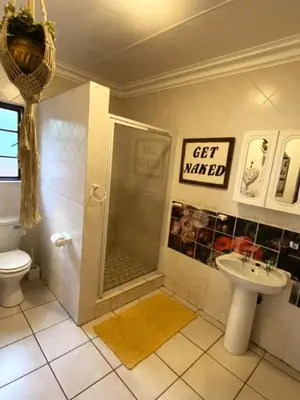 a bathroom with a shower and a toilet and a sink at Piano Inn in Centurion