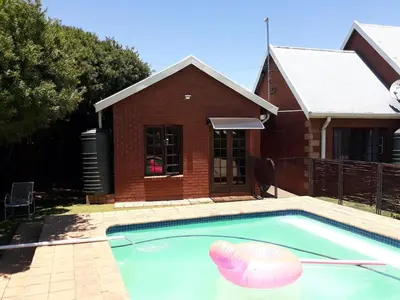 a house with a swimming pool with a house at Piano Inn in Centurion