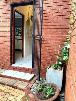 an open door to a brick house with plants at Piano Inn in Centurion