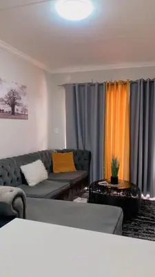 a living room with a couch and curtains at Stunning One Bedroom Apartment in Midrand in Midrand