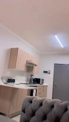 a kitchen with a couch in the middle of a room at Stunning One Bedroom Apartment in Midrand in Midrand