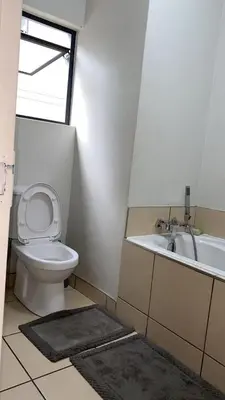 a bathroom with a toilet and a sink and a tub at Stunning One Bedroom Apartment in Midrand in Midrand