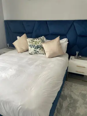 a bed with a blue headboard and pillows on it at Serenity at Homely Escapes in Phalaborwa