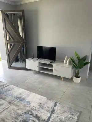 a living room with a tv and a mirror at Serenity at Homely Escapes in Phalaborwa