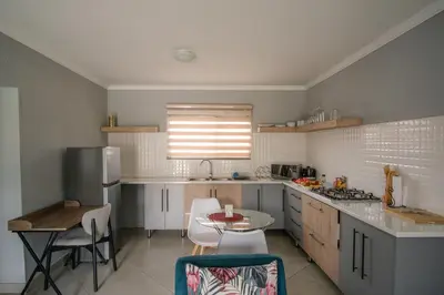 a kitchen with a table and a small table and chairs at Serenity at Homely Escapes in Phalaborwa