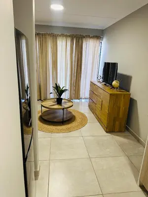 a living room with a table and a tv at Homely Stay 2 in Kempton Park