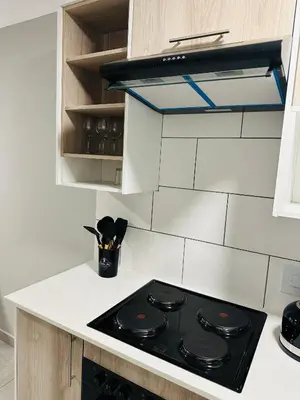 a black stove top in a white kitchen at Homely Stay 2 in Kempton Park