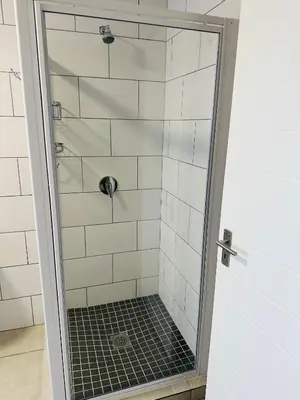 a shower with a glass door in a bathroom at Homely Stay 2 in Kempton Park