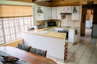 a kitchen with a counter and a table in it at Namagong in Marloth Park