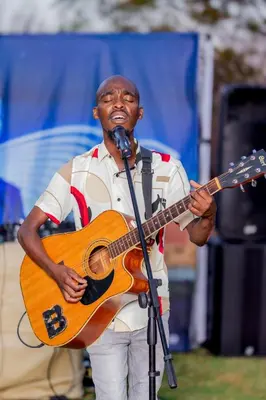 a man holding a guitar and a microphone at 156 Euphoria Boutique Villa - Euphoria Golf Estate Hydro in Naboomspruit